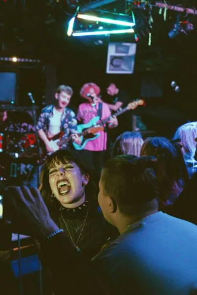 Energetic fan singing along — Close-up of a passionate concertgoer singing along loudly with excitement during a lively music gig.