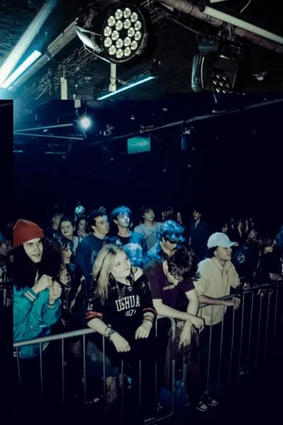 Crowded venue enjoying show — Young crowd enjoying a live concert, some dancing, all immersed in the intense music experience.